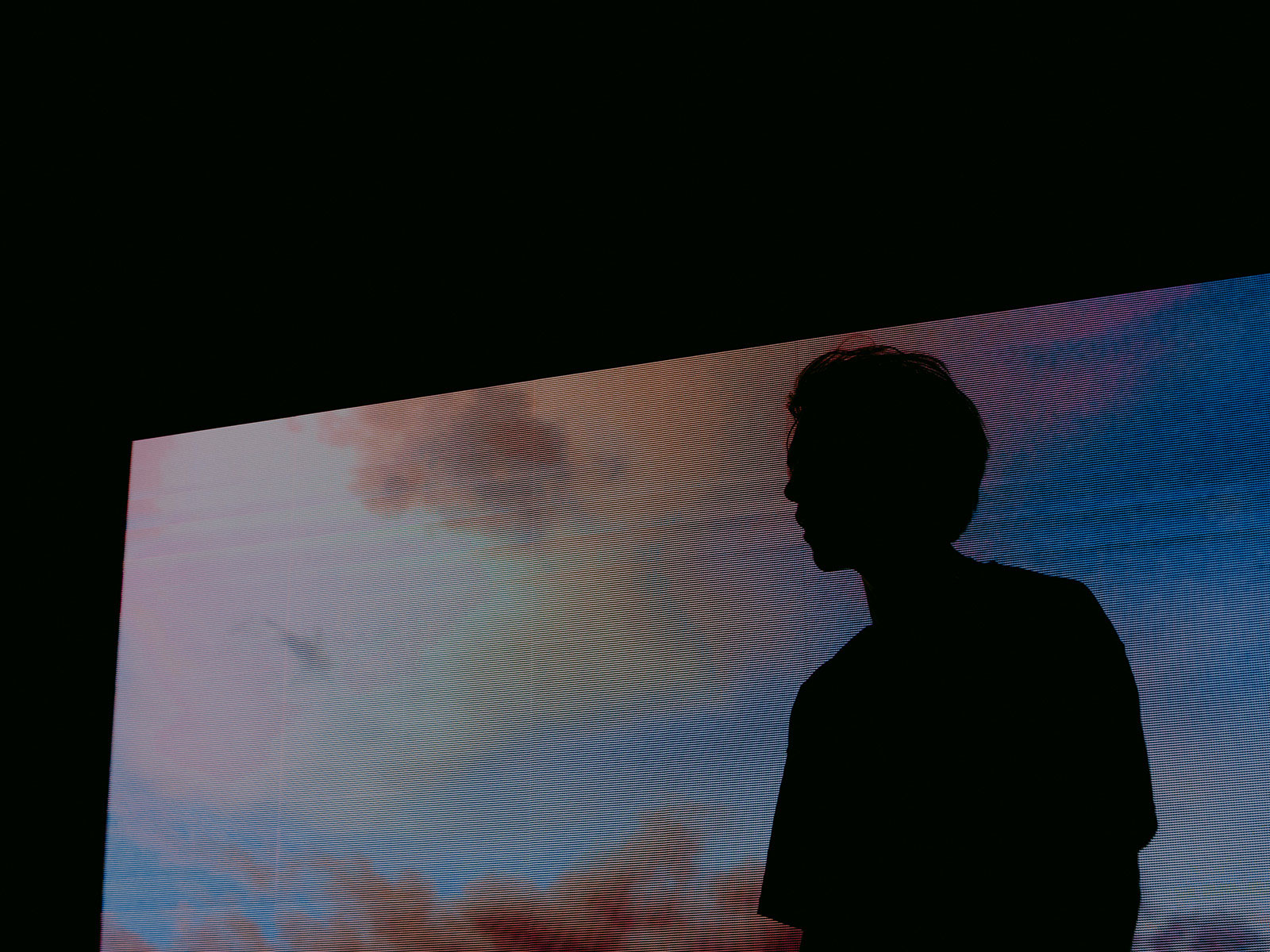 Sillouhette of young man against a large digital screen
